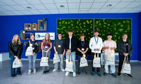Gruppe junger Auszubildender mit Ludwig Meister-Taschen im Empfangsbereich des Unternehmens