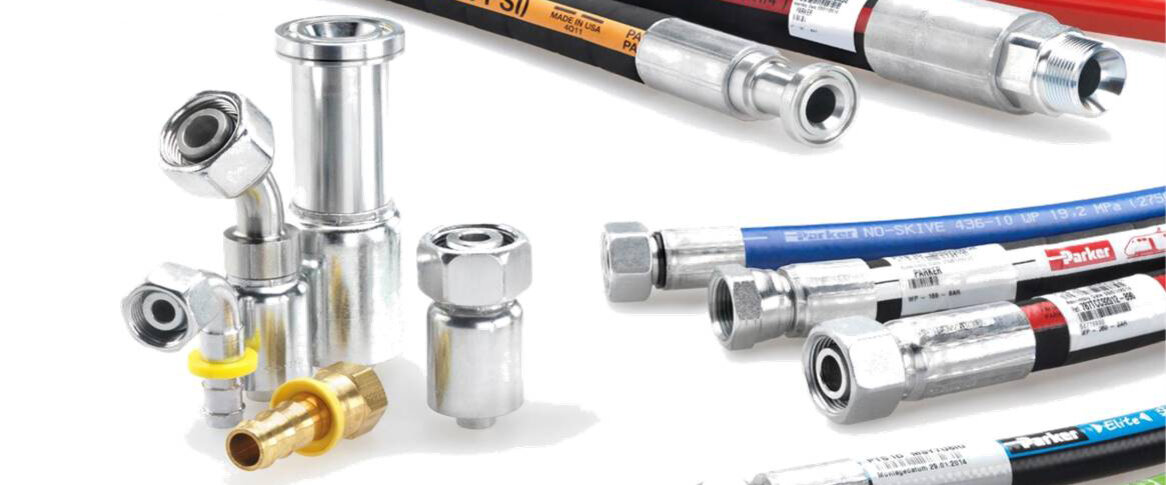 Verschiedene Hydraulikschläuche und Metallarmaturen liegen nebeneinander.