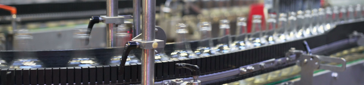 Leere Glasflaschen auf Förderband in automatisierter Abfüllanlage