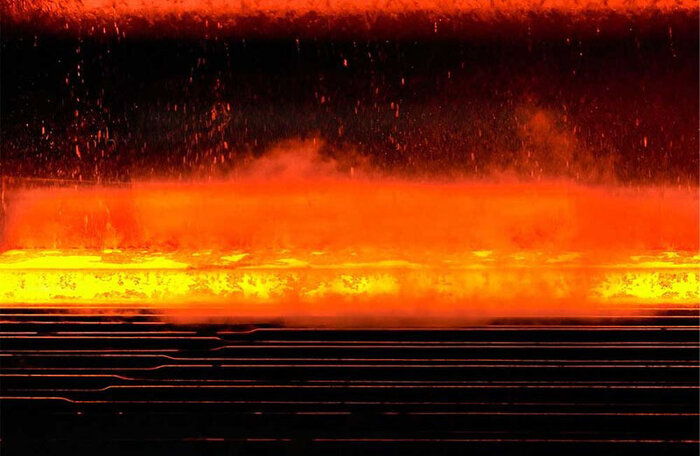 Rotglühender Stahl wird im Walzwerk mit Wasserstrahlen gekühlt