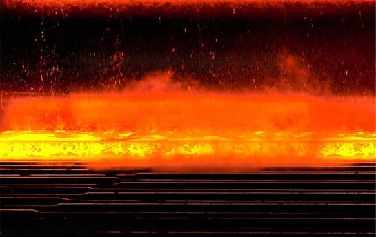 Rotglühender Stahl wird im Walzwerk mit Wasserstrahlen gekühlt