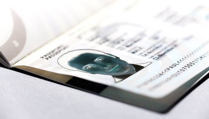 Nahaufnahme eines geöffneten Reisepasses mit sichtbarem Passbild und Text.