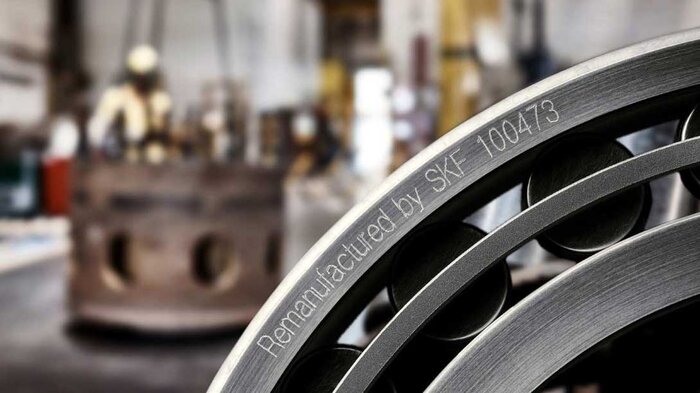 Ein wiederaufbereitetes Lager von SKF mit der Gravur "Remanufactured by SKF - 100473" im Vordergrund.