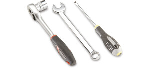 Eine Ratsche, ein Schraubenschlüssel und ein Schraubendreher liegen nebeneinander.