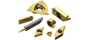 Mehrere goldfarbene Werkzeugschneidplatten und Einsätze in verschiedenen Formen liegen auf weißem Hintergrund.