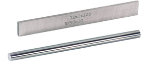 Eine rechteckige Metallplatte mit Aufschrift und ein runder Metallstab nebeneinander liegend.