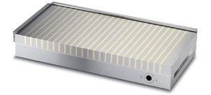 Eine magnetische Aufspannplatte mit gelben Streifen auf einer grauen Fläche.